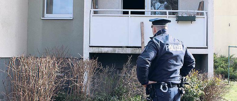 Ausgebrannt. Polizist vor der betroffenen Wohnung am Humboldtring.