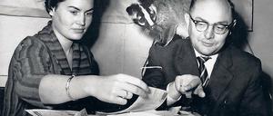 Mit Schleichkatze am Schreibtisch. Tierpark-Direktor Heinrich Dathe und seine Sekretärin Irene Engelmann versuchen die Zettelwirtschaft auf dem Schreibtisch des Zoologen zu überblicken. Der Larvenroller, eine Schleichkatze aus Südasien, schaut dem Treiben neugierig zu.