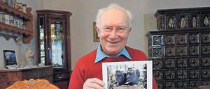 Sigmund Jähn mit Fotos von der Aufstellung der Doppelbüste für ihn und Bykowski in Potsdam im Jahr 1988.