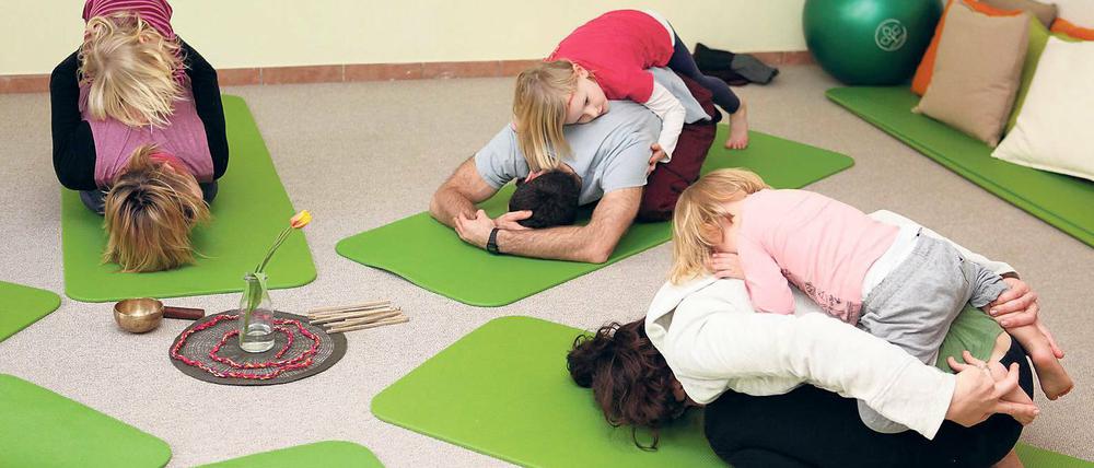 Rückenlage. Der enge Kontakt zwischen Eltern und Kindern ist Bestandteil des Konzeptes der neuen Familien-Yogakurse im FrauRaum. Ziel ist es weniger, die perfekte Übung abzuliefern, sondern Familien den gemeinsamen Spaß an der Bewegung zu vermitteln.