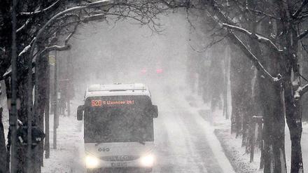 Schneegestöber. Ein Bus auf glatter Straße nahe Dreilinden.