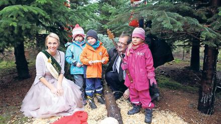 Erste Kunden. Der fünfjährige Tayler (3.v.l.) und seine Freunde vom SOS-Kinderdorf basteln Schmuck für den Baum, den Jörg Vogelsänger abgesägt hat. Zur Saisoneröffnung war auch die deutsche Baumkönigin Saskia Blümel angereist.