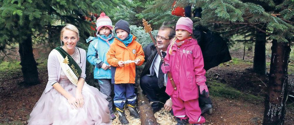 Erste Kunden. Der fünfjährige Tayler (3.v.l.) und seine Freunde vom SOS-Kinderdorf basteln Schmuck für den Baum, den Jörg Vogelsänger abgesägt hat. Zur Saisoneröffnung war auch die deutsche Baumkönigin Saskia Blümel angereist.