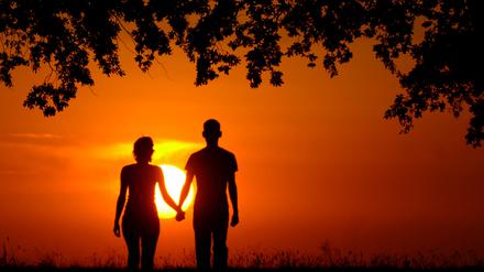 Ein junges Liebespaar Hand in Hand nahe dem brandenburgischen Müncheberg im Sonnenuntergang.