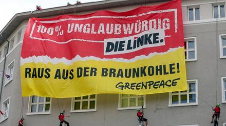 Greenpeace-Aktivisten seilen sich an der Parteizentrale der Linken in Berlin ab. Es geht - mal wieder - um die Braunkohle in Brandenburg.
