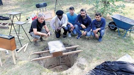 Musik im Sand. Bei der Installation „Hole in the Garden“ ließ Carsten Hensel (l.) mit Flüchtlingen aus dem Nachbarhaus Schallwellen-Muster im Sand formen.
