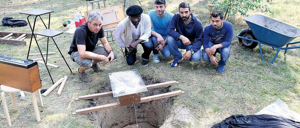 Musik im Sand. Bei der Installation „Hole in the Garden“ ließ Carsten Hensel (l.) mit Flüchtlingen aus dem Nachbarhaus Schallwellen-Muster im Sand formen.