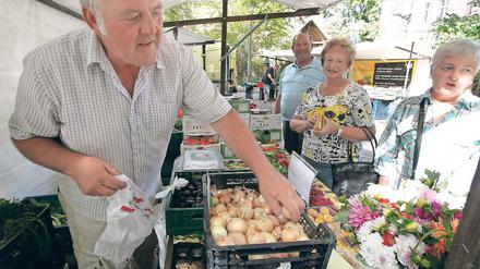 So geht Markt. Jürgen Deutscher verkauft auf Potsdams jüngstem Markt Gemüse aus Werder – und weiß seine Ware gut anzupreisen. Da nehmen Kunden, die eigentlich nur einen Herbstblumenstrauß wollten, schnell auch noch Zwiebeln und Himbeeren.