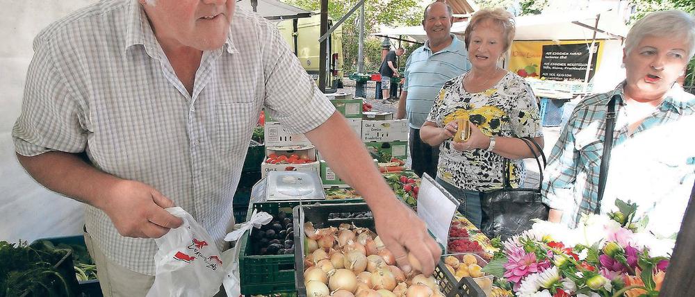 So geht Markt. Jürgen Deutscher verkauft auf Potsdams jüngstem Markt Gemüse aus Werder – und weiß seine Ware gut anzupreisen. Da nehmen Kunden, die eigentlich nur einen Herbstblumenstrauß wollten, schnell auch noch Zwiebeln und Himbeeren.