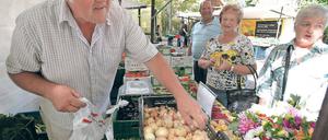So geht Markt. Jürgen Deutscher verkauft auf Potsdams jüngstem Markt Gemüse aus Werder – und weiß seine Ware gut anzupreisen. Da nehmen Kunden, die eigentlich nur einen Herbstblumenstrauß wollten, schnell auch noch Zwiebeln und Himbeeren.