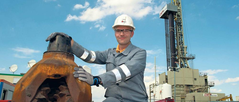 Ein Mitarbeiter des deutsch-kanadischen Central European Petroleum mit einem Bohrkopf vor dem Bohrturm im brandenburgischen Guhlen.