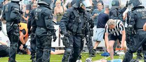 Im Einsatz. Die Polizei und ein Fan, der einem Verletzten helfen will.