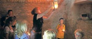 Kerzenlicht im Keller. Welche Schätze sie im Hofgärtnerhaus einst barg, zeigt Petra Wesch den Kindern beim Sommerfest. Am Sonntag wurde dazu noch Gold entdeckt.