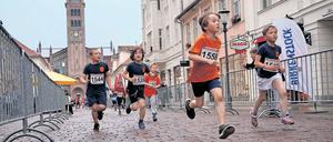 Die Shoppingmeile als Laufparcour. Die Brandenburger Straße ist für die Schüler bei der Preußischen Meile eine lange Zielgerade, für die Teilnehmer des Hauptlaufes eine vier Mal zu absolvierende Passage.