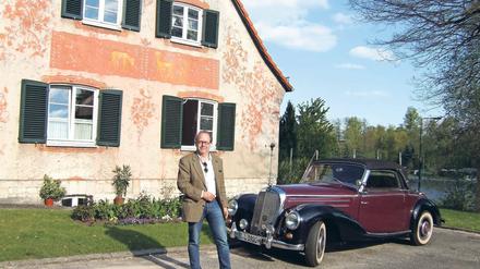 Fährt Oldtimer. Investor Michael Linckersdorff vor einem der Doppelhäuser in der Schleusensiedlung.