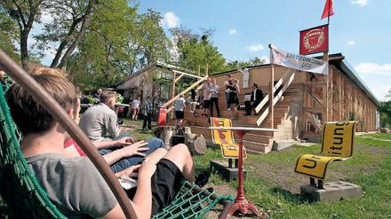 Entspannen mit Holz. Gäste können am Campus seit Montag in Hängematten entspannen oder im Clubhaus Tischkicker spielen. Die Bauten sollen zwei Jahre lang stehen.