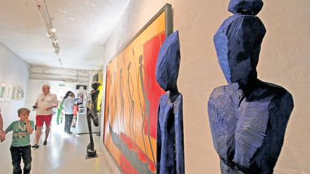 Merkwürdige Alienfiguren. Der Künstler Chris Hinze sägt aus Holz Skulpturen, die mit ihren Alienschädeln und den dünnen, langgestreckten Körpern durchaus verstörend sein können – erst recht in diesem beeindruckend schimmernden Blau.