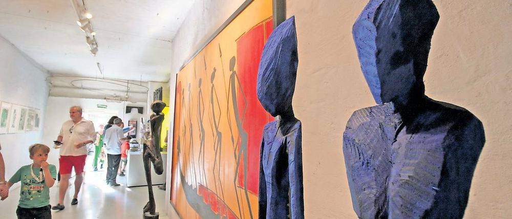 Merkwürdige Alienfiguren. Der Künstler Chris Hinze sägt aus Holz Skulpturen, die mit ihren Alienschädeln und den dünnen, langgestreckten Körpern durchaus verstörend sein können – erst recht in diesem beeindruckend schimmernden Blau.