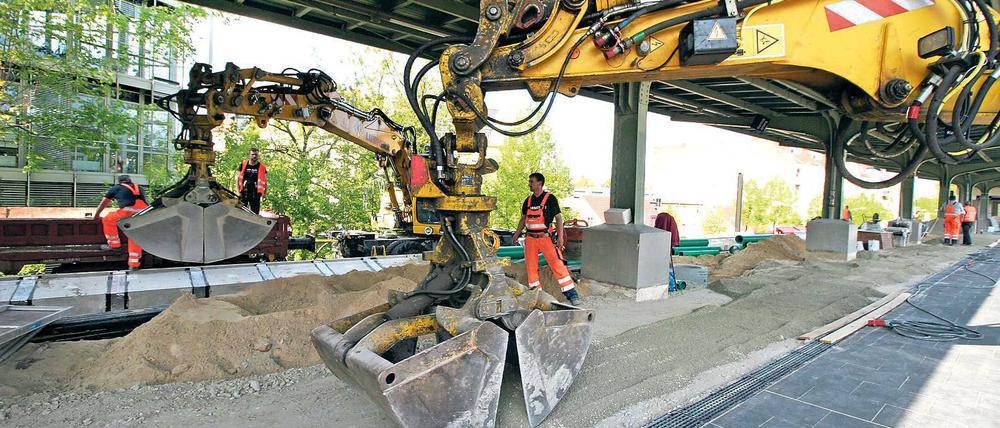 Zärtliches Baggern. Mit viel Gefühl wird der Sand über den Bahnsteig verteilt. Ab Freitag ist eine Seite wieder begehbar. Andreas Krause überwacht die Arbeiten. Auch die Stützmauern des Dammes werden erneuert, die Geschäfte im Bahnhof sind geöffnet.