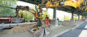 Zärtliches Baggern. Mit viel Gefühl wird der Sand über den Bahnsteig verteilt. Ab Freitag ist eine Seite wieder begehbar. Andreas Krause überwacht die Arbeiten. Auch die Stützmauern des Dammes werden erneuert, die Geschäfte im Bahnhof sind geöffnet.