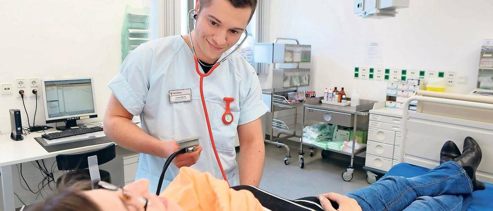 Nah dran. Krankenpflege-Azubi Justus Dreier im Einsatz im Potsdamer St. Josefs- Krankenhaus. Der 21-Jährige misst einer Patientin in der Notaufnahme den Blutdruck.