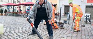 Während die Mitarbeiter des Bauhofs noch die Poller in der Dortustraße verankern, testet der pensionierte Revierpolizist Joachim Pfeifer die Funktionsfähigkeit des abklappbaren Exemplars. Die Sperren sollen illegale Autofahrten durch die Fußgängerzone unterbinden.