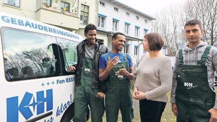 Sprachliche Hürden. Debesay Medhane und Mohamed Ahmed Jama (v.l.) unterhalten sich mit einer Karstedt-Mitarbeiterin. Rechts steht der nächste Anwärter für einen Job in der Reinigungsfirma. Er kommt aus Pakistan.