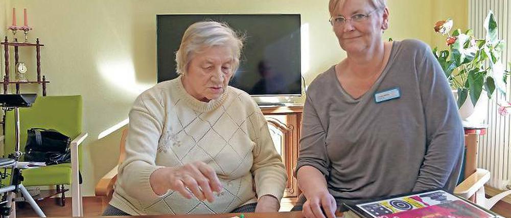Cornelia Möller (r.) kümmert sich in der Wohngemeinschaft in Teltow um acht Senioren, unter anderem um die 82-jährige Brigitte Hinz. Sechs Stunden verbringt sie täglich mit den Rentnern, kocht und spielt Gesellschaftsspiele.