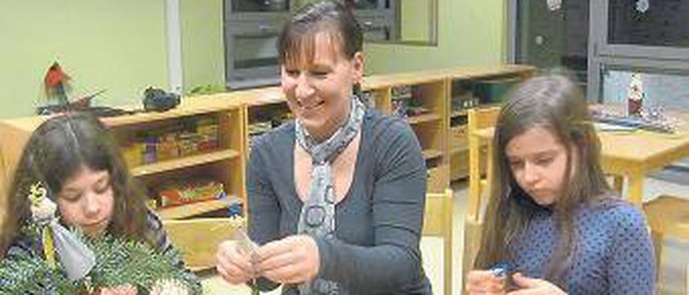 Engelsfigur. Eine Erzieherin bastelt mit Kindern in der Lindenhof-Schule.