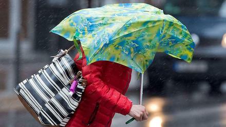 Starker Regen und Sturm - hier eine Passantin in Frankfurt am Main.