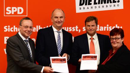 Ein Jahr Rot-Rot in Brandenburg: SPD-Fraktionsvorsitzender Klaus Ness, Ministerpräsident Dietmar Woidke (SPD), der Landesvorsitzende der Linkspartei, Christian Görke und die Fraktionsvorsitzende der Linkspartei, Margitta Mächtig mit dem Koalitionsvertrag in den Händen.