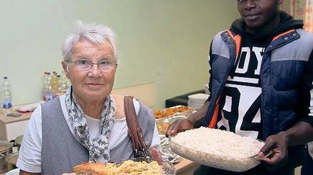 Kuchen und Reis. Bewohner des Flüchtlingsheims kochten Mittagessen, Anwohner brachten Kuchen für die Kaffeetafel.