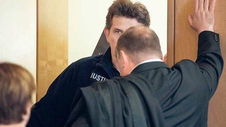 Tot wegen 800 Euro. Der Anwalt (v.) des 38-Jährigen spricht mit einem Justizmitarbeiter, damit dieser den Angeklagten unsichtbar für die Fotografen und Kamerateams erst wenige Sekunden vor Verhandlungsbeginn in den Saal führt.