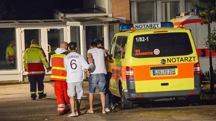 Flüchtlinge werden vor dem Asylbewerberheim in Massow (Brandenburg) von Rettungskräften betreut.
