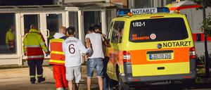 Flüchtlinge werden vor dem Asylbewerberheim in Massow (Brandenburg) von Rettungskräften betreut.