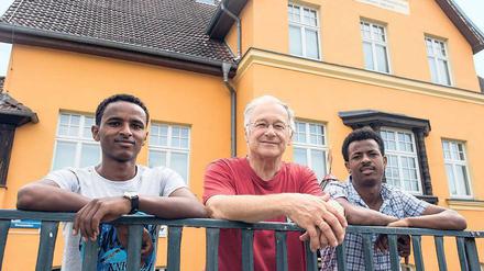 Martin Patzelt (M., CDU) und die beiden Flüchtlinge aus Eritrea Haben (l., 19) und Awet (r., 24) am Gemeindehaus in Briesen.