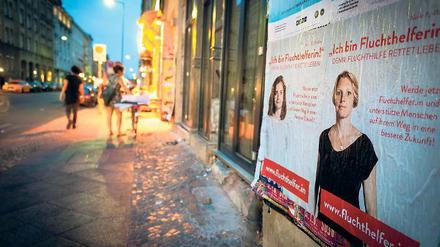 Mit Plakat. Auch in Kreuzberg wird für die Aktion geworben, bei der Privatleute Flüchtlinge nach Deutschland bringen sollen.