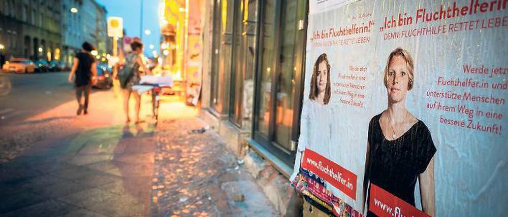 Mit Plakat. Auch in Kreuzberg wird für die Aktion geworben, bei der Privatleute Flüchtlinge nach Deutschland bringen sollen.