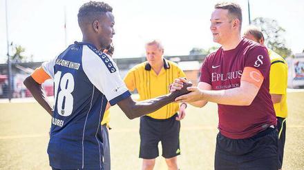 Marc Hübsch, Kapitän des USV Potsdam, begrüßt Abdihafid Ahmed von Welcome United 03 am Anstoßkreis.