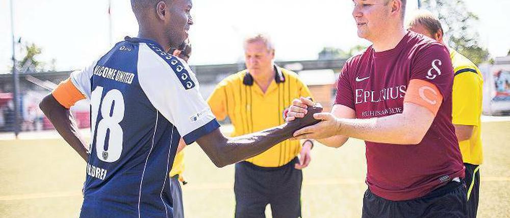 Marc Hübsch, Kapitän des USV Potsdam, begrüßt Abdihafid Ahmed von Welcome United 03 am Anstoßkreis.