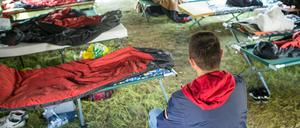 Ein Asylbewerber aus Albanien sitzt in einem Gruppenzelt auf dem Gelände der Zentralen Erstaufnahmestelle in Eisenhüttenstadt.