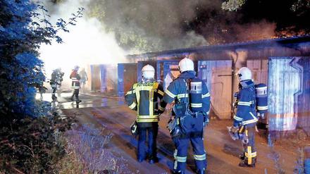 Im Einsatz. Feuerwehrmänner löschten den Brand in einer Garagenanlage.