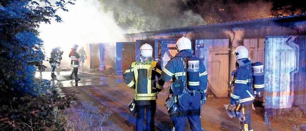 Im Einsatz. Feuerwehrmänner löschten den Brand in einer Garagenanlage.