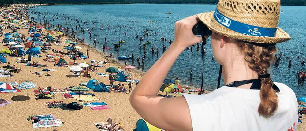 Gruppenschwitzen. Viele Menschen suchten am Wochenende wie hier am vollen Badestrand des Helenesees bei Frankfurt (Oder) Abkühlung. Für einige Menschen wurde das Bad in der Hitze zur tödlichen Falle.