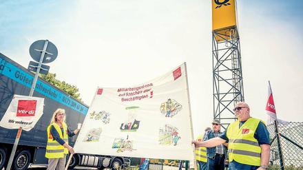 Schichtarbeit auf dem Streikposten. Die Streikenden der Deutschen Post vor dem Briefverteilzentrum in Stahnsdorf haben ihre Arbeit niedergelegt. Seit dem 8. Juni demonstrieren sie vor dem Werkstor für bessere Arbeitsbedingungen. Währenddessen stapeln sich in den Hallen die Briefe und Pakete. Ein Ende des Streiks scheint noch nicht in Sicht.