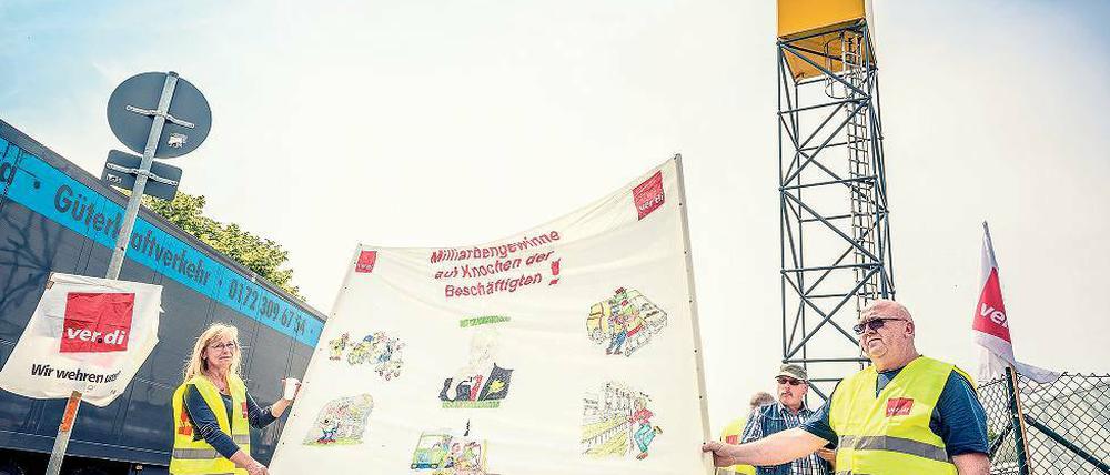 Schichtarbeit auf dem Streikposten. Die Streikenden der Deutschen Post vor dem Briefverteilzentrum in Stahnsdorf haben ihre Arbeit niedergelegt. Seit dem 8. Juni demonstrieren sie vor dem Werkstor für bessere Arbeitsbedingungen. Währenddessen stapeln sich in den Hallen die Briefe und Pakete. Ein Ende des Streiks scheint noch nicht in Sicht.