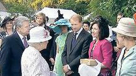 Übergabe. K. Reiche (r.) zeigt der Queen den Kirchen-Stein.
