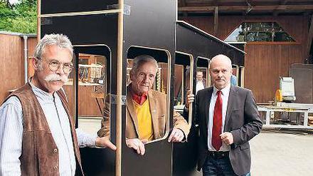 Modell stehen. Hermann Lamprecht (Mitte) und Teltows Bürgermeister Thomas Schmidt (rechts) am Modell der Straßenbahn, das beim Umzug zu sehen sein wird.