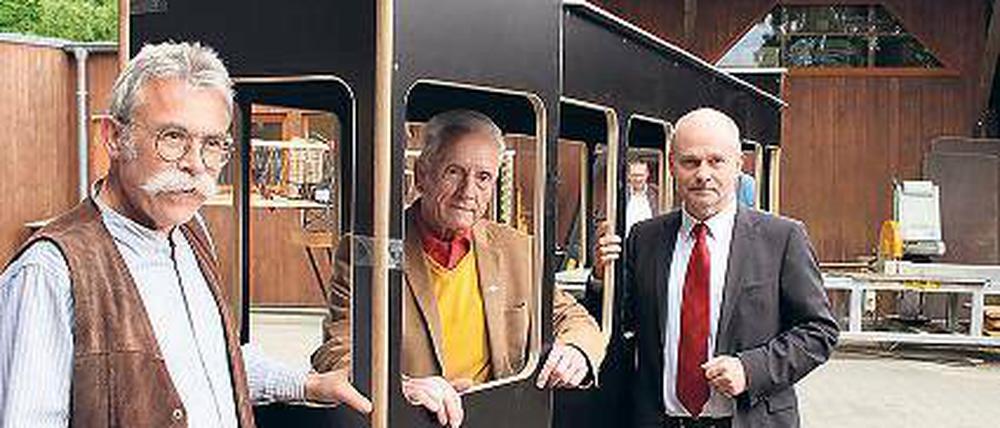 Modell stehen. Hermann Lamprecht (Mitte) und Teltows Bürgermeister Thomas Schmidt (rechts) am Modell der Straßenbahn, das beim Umzug zu sehen sein wird.