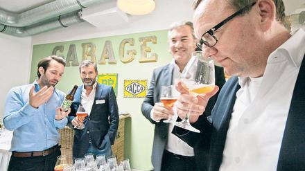 Bier bewusst genießen. Beim „Garagen-Pitch“ probierten potenzielle Geldgeber die Craftbiere des Potsdamer Unternehmens Bier-Deluxe. Hier erklärt Marketingleiter Christoph Klischan (l.) den Testern sein Produkt.